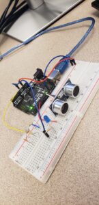 small circuit on a bread board with an ultrasonic sensor and a two LEDs